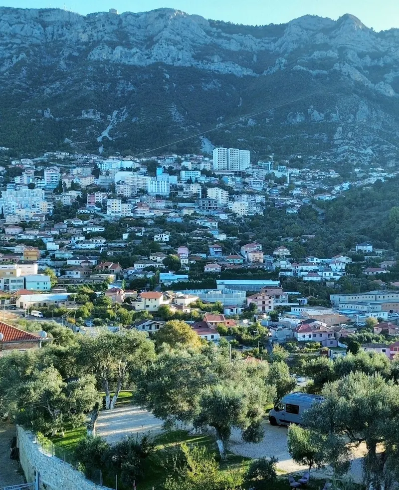 Krujë spread below its mountain, seen from above the campsite's olive grove